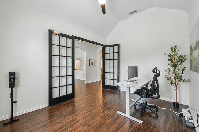 Office area with arched walkways, french doors, lofted ceiling, wood finished floors, and ceiling fan | Image 5