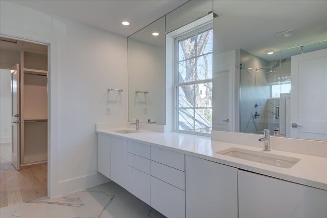 Large double vanity, wall of mirrors, chrome finishes and - yet again - tons of natural light. Access to the custom designed walk-in closet and additional flex space beyond. SEE VIRTUAL TOUR LINK WITH INTERACTIVE FLOOR PLAN AND 3D WALK THRU. | Image 24