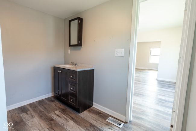 bathroom with baseboards, visible vents, wood finished floors, and vanity | Image 35