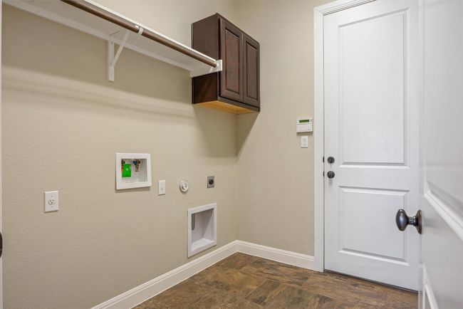 Laundry area featuring hookup for either gas or electric dryer, cabinet space, hookup for a washing machine | Image 20