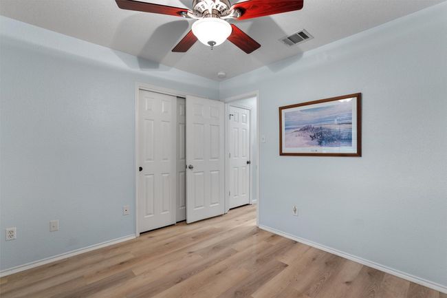 Unfurnished bedroom featuring light wood-style floors, ceiling fan, and a closet | Image 25