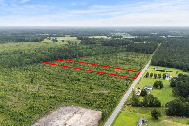 Aerial view of sparsely populated area with property boundaries highlighted and a forest | Image 4
