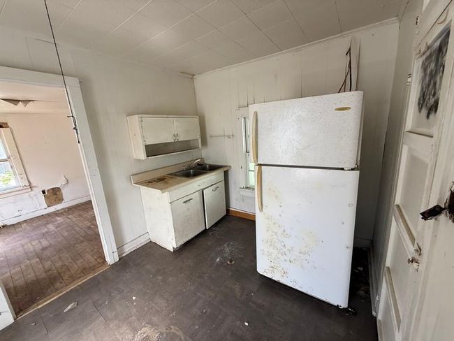 Kitchen featuring freestanding refrigerator, a sink, and light countertops | Image 9