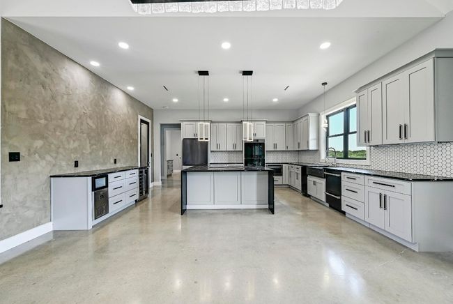 Incredible cabinetry storage with custom designed cabinetry including a built-in dry bar buffet with a wine fridge and an ice maker. | Image 14