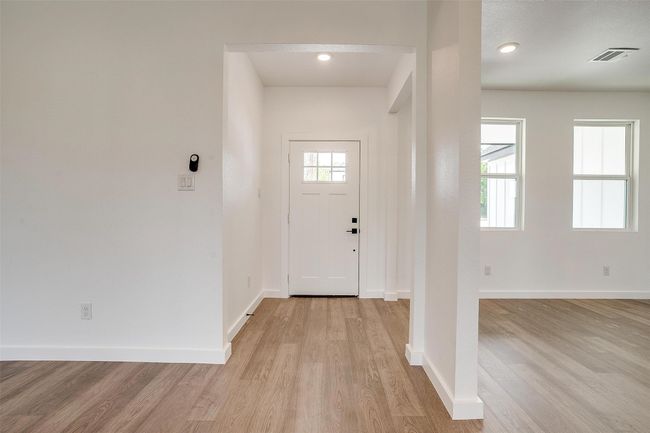 Foyer with light wood finished floors, visible vents, and baseboards | Image 8