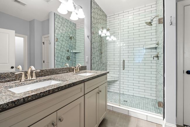 Bathroom with a stall shower, double vanity, and tile patterned floors | Image 14
