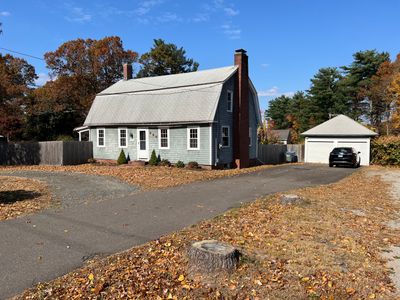 Lovely setting for this colonial offering 4, to possibly 5 bedrooms! Eat in kitchen, Formal Dining Room, Living Room with fireplace 1 1/2 baths.Replacement windows, wood floors throughout the home and a two car garage! Did you see that side porch? | Image 2