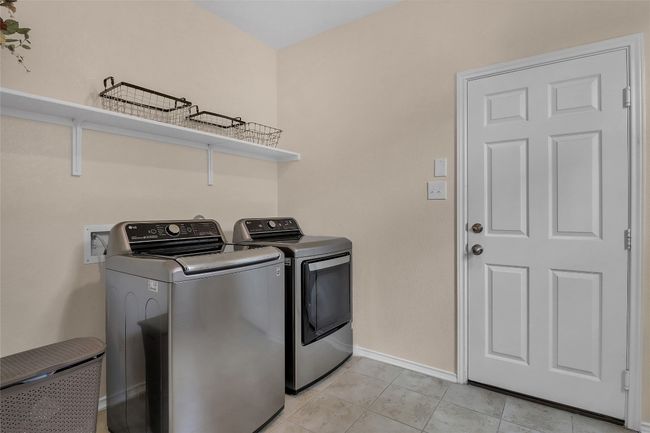 Laundry room featuring washing machine and clothes dryer, baseboards, and light tile patterned floors | Image 13