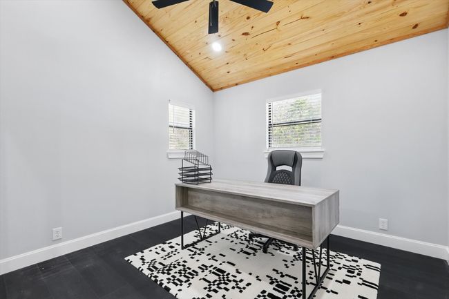 Office space with dark wood-style flooring, wood ceiling, vaulted ceiling, ceiling fan, and baseboards | Image 28