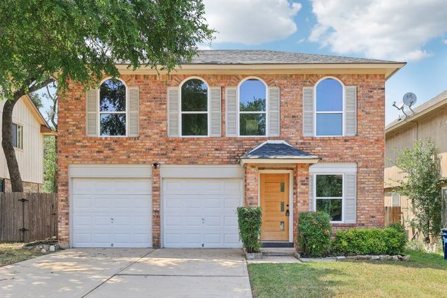View of front of property featuring driveway, brick siding, and an attached garage | Image 9