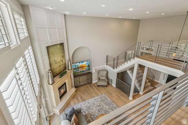 Living area with wood finished floors, a glass covered fireplace, and recessed lighting | Image 38