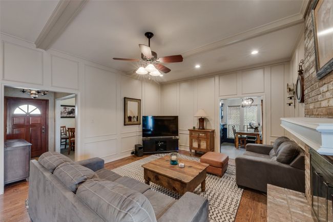 Living area featuring a decorative wall, light wood-style floors, crown molding, a ceiling fan, and recessed lighting | Image 8