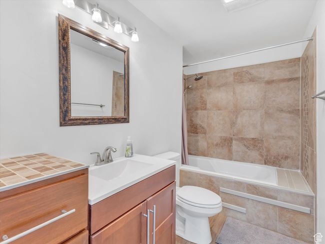 Bathroom featuring tiled shower / bath combo, toilet, and vanity | Image 35