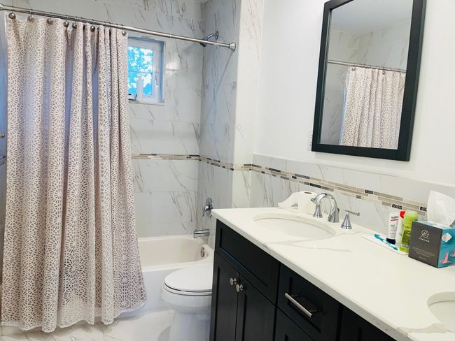 Full bath with double vanity, shower / bath combo, and tile walls | Image 12