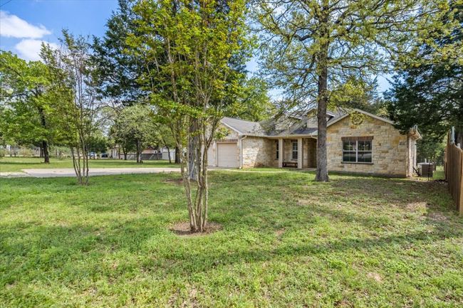 Single story home with a front yard, central AC, an attached garage, stone siding, and fence | Image 26