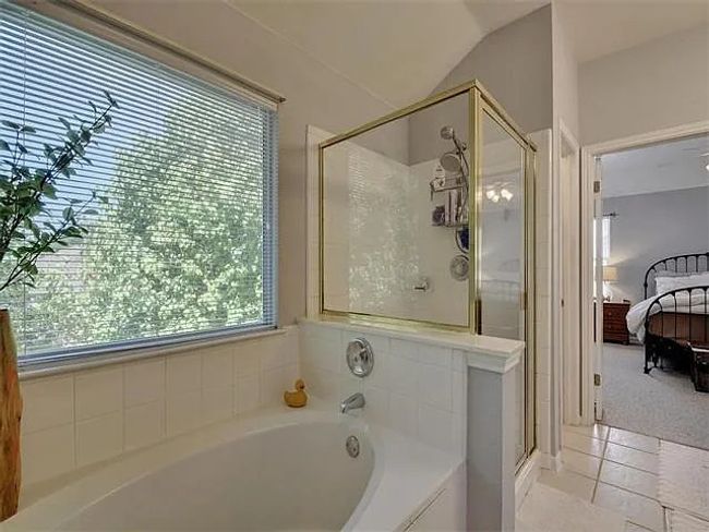 Full bath with ensuite bathroom, a shower stall, a garden tub, tile patterned floors, and lofted ceiling | Image 18