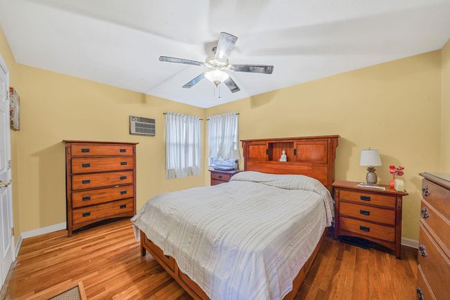Bedroom with light wood-style flooring, baseboards, and a ceiling fan | Image 12