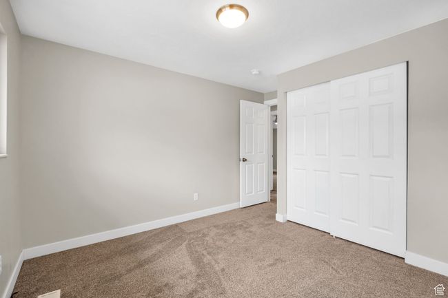Unfurnished bedroom with a closet, baseboards, and carpet floors | Image 15