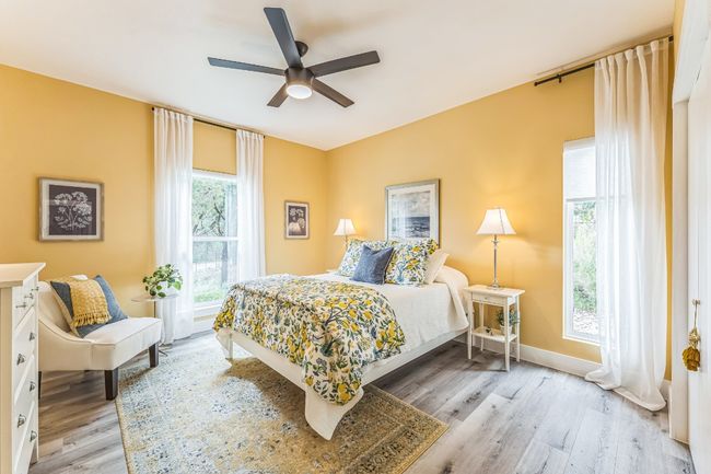 Bedroom featuring light wood-style floors, ceiling fan, and baseboards. | Image 19