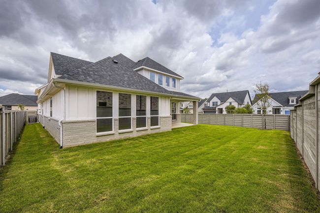 Back of house with board and batten siding, a shingled roof, a fenced backyard, and brick siding | Image 28