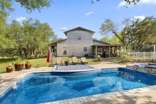 View of pool with a patio, a pool with connected hot tub, and central AC unit | Image 10