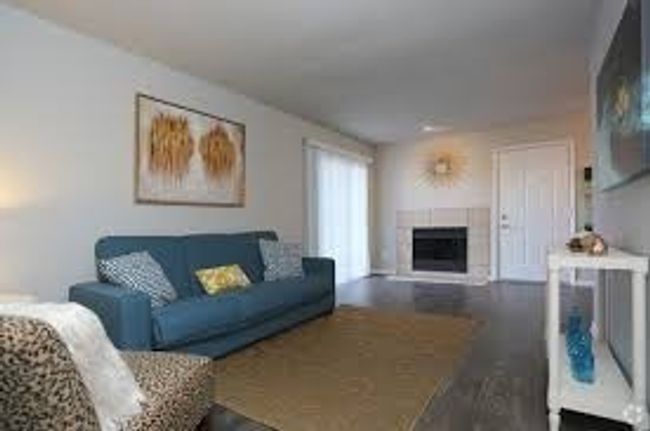 Living room featuring dark wood finished floors and a fireplace | Image 8