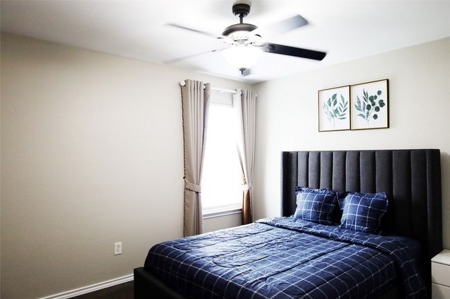 Bedroom with a ceiling fan, baseboards, multiple windows, and dark wood-type flooring | Image 12