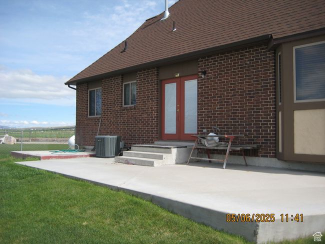 Back of house with french doors, fence, central AC unit, a patio area, and brick siding | Image 6