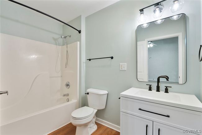 Full bathroom featuring vanity, wood finished floors, and washtub / shower combination | Image 15