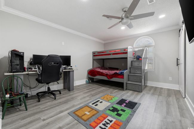 Bedroom with wood finished floors, ornamental molding, baseboards, an office area, and recessed lighting | Image 16
