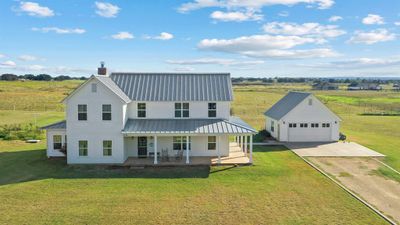 View of front facade featuring an outbuilding, a front lawn, covered porch, and a garage | Image 1