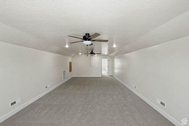 Bonus room featuring vaulted ceiling, baseboards, visible vents, carpet, and a ceiling fan | Image 30