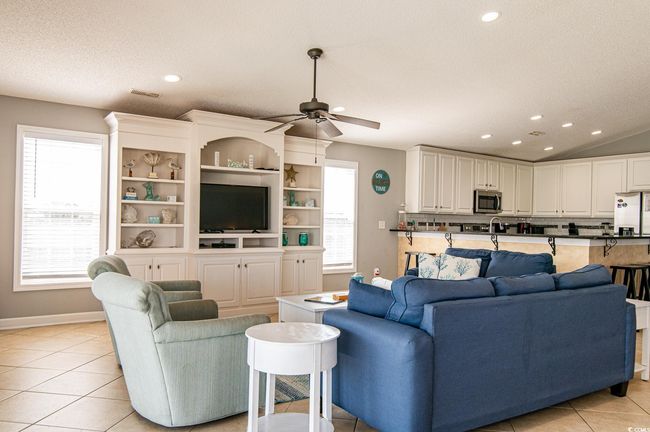 Living room with recessed lighting, ceiling fan, light tile patterned flooring, baseboards, and lofted ceiling | Image 24