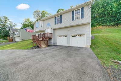 Bi-level home featuring a garage and a front lawn | Image 2