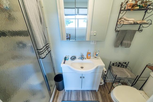 Bathroom featuring hardwood / wood-style floors, a shower with shower door, vanity, and toilet | Image 15