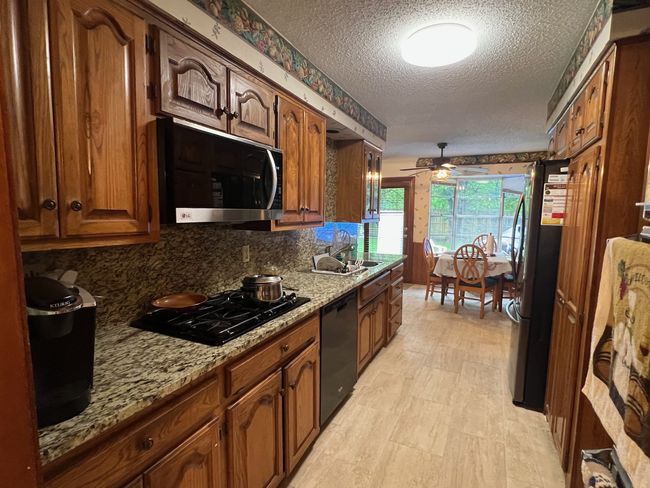 Kitchen with a textured ceiling, decorative backsplash | Image 6