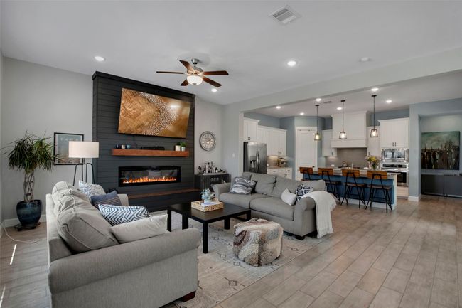 Living room featuring light wood-style floors, ceiling fan, a large fireplace, recessed lighting, and baseboards | Image 5
