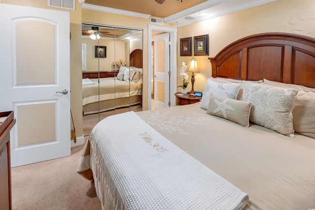 Bedroom featuring ornamental molding, light colored carpet, a closet, and a ceiling fan | Image 25
