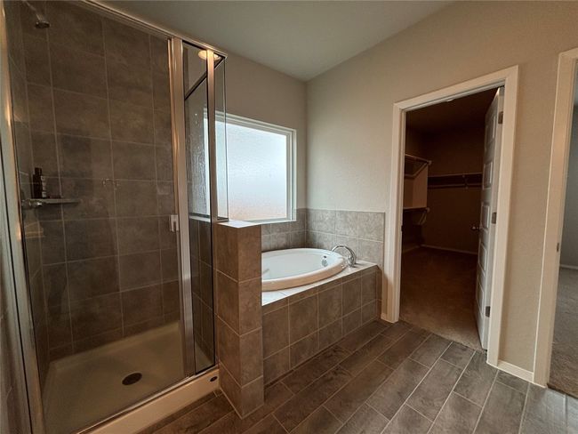 Full bathroom featuring a stall shower, a garden tub, and a spacious closet | Image 24