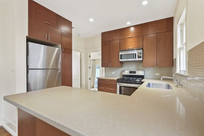 Kitchen with appliances with stainless steel finishes, tasteful backsplash, a peninsula, recessed lighting, and modern cabinets | Image 6