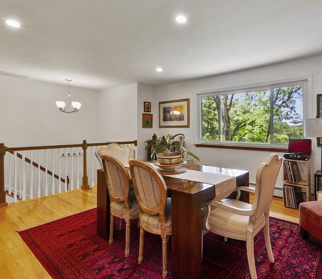 Dining room with wood finished floors, recessed lighting, a chandelier, and a baseboard heating unit | Image 7