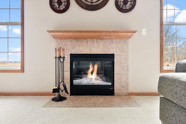 Cozy gas fireplace with elegant tile surround and a classic wood mantel—perfect for chilly Minnesota evenings. | Image 10