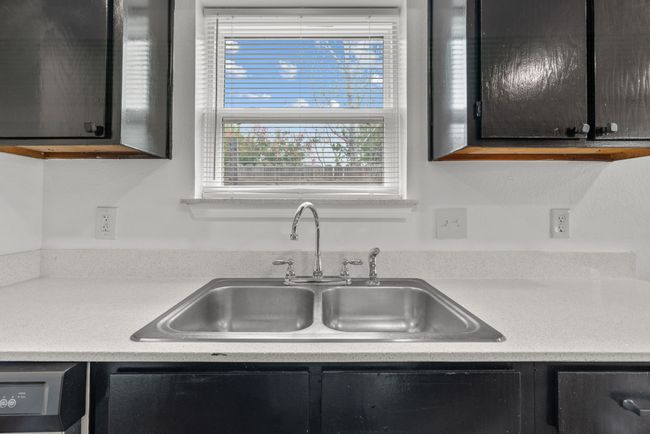 Kitchen with dark cabinets, light countertops, and dishwashing machine | Image 19