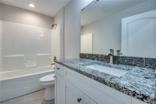 Full bathroom with toilet, wood tiled floor, bathtub / shower combination, and vanity | Image 39