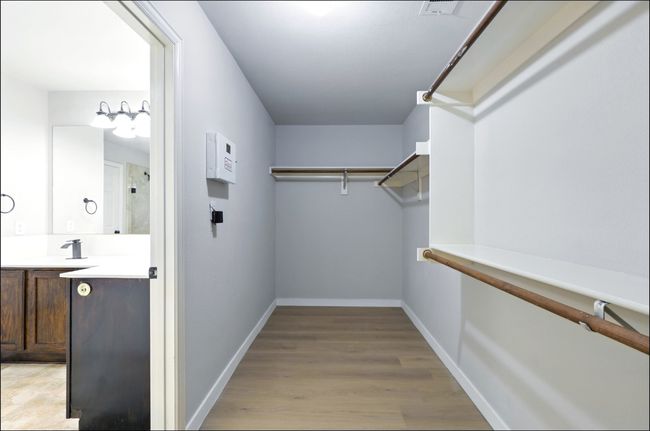 Spacious closet with light wood finished floors | Image 34