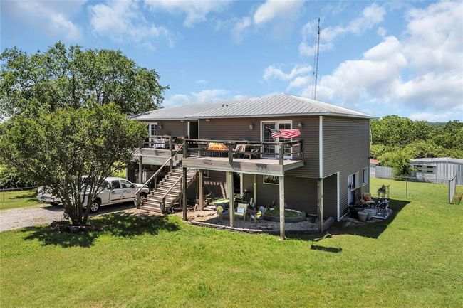 Rear view of house with stairway, a wooden deck, and metal roof | Image 45