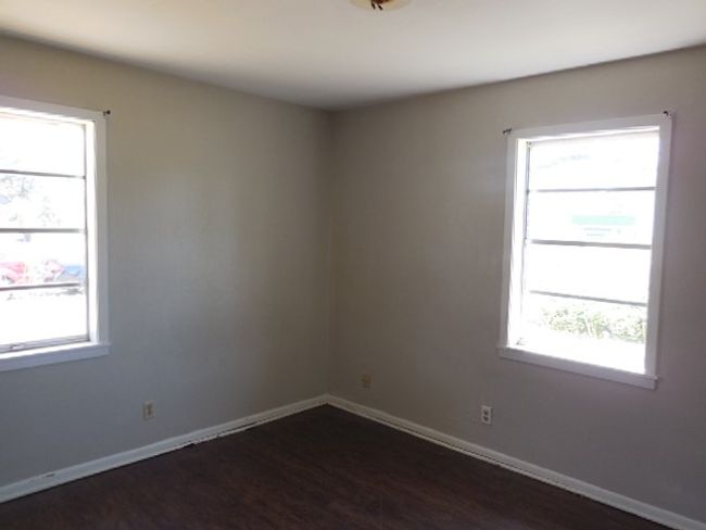 Unfurnished room featuring baseboards and dark wood-style floors | Image 8