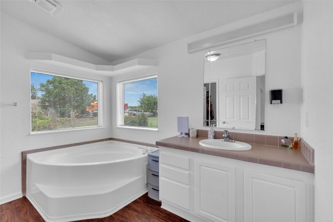 Bathroom with a bath, lofted ceiling, vanity, and wood finished floors | Image 19