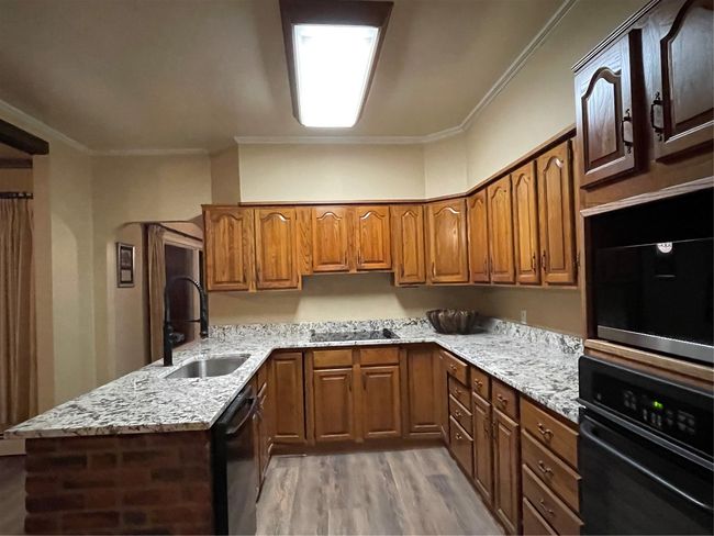 Kitchen featuring dishwasher, sink, ornamental molding, wall oven, and light hardwood / wood-style floors | Image 12