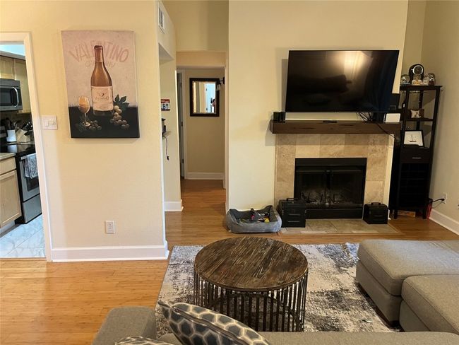 Living room with wood finished floors and a tiled fireplace | Image 14